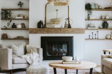 an elegant modern farmhouse living room with a built-in fireplace, built-in wooden shelves, chic neutral furniture, a tassel chandelier