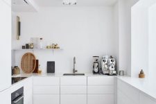 06 a minimalist white kitchen with sleek cabinets, sleek countertops, a shelf and built-in appliances is a chic space