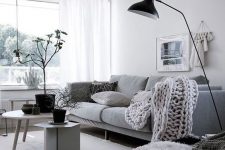 09 a dreamy Scandinavian living room in white, black and grey, with a comfy sofa, grey chairs, black accessories for more drama