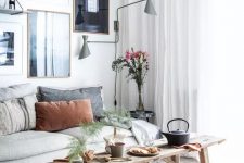 15 a Scandinavian living room with a neutral sofa, a wooden bench, a lovely gallery wall and grey sconces is chic