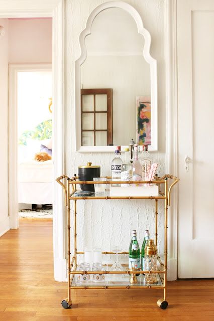 an elegant gold bamboo bar cart is a stylish addition and a must for a millennial living room