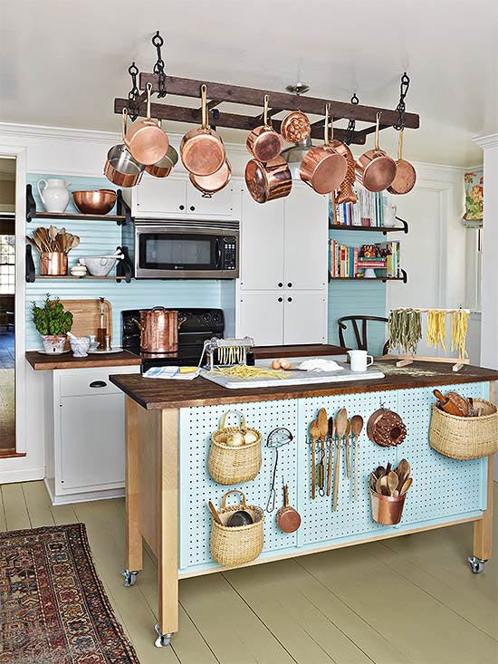 a kitchen island on wheels and with pegboard with hooks for storing stuff plus a ladder for hanging things over it