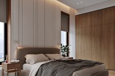a beautiful contemporary bedroom with built-in lights, a grey upholstered bed, grey bedding and curtains, wooden nightstands and a sleek storage unit