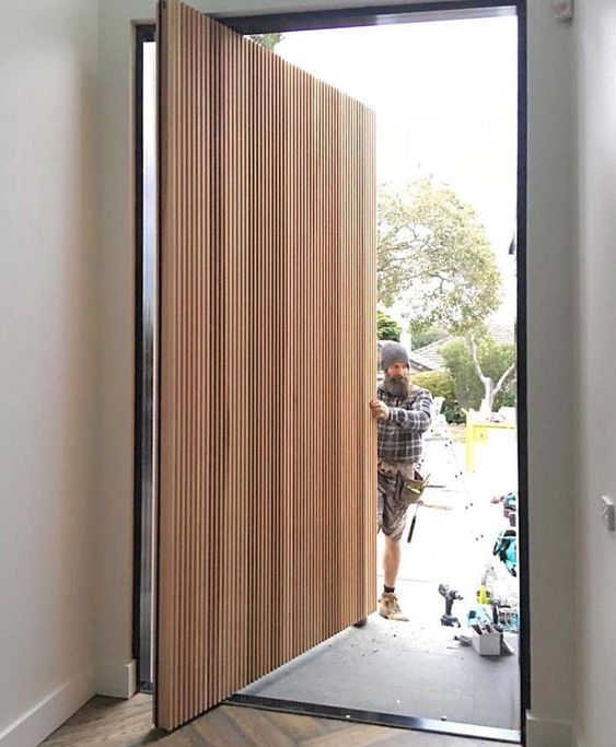 a beautiful light-stained wood slab pivot door is a lovely idea for a contemporary home and it looks amazingly clean and sleek