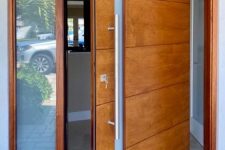 a beautiful modern rich-stained pivot wooden door with a frosted glass insert is a very cool idea for a modern entrance