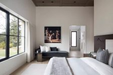 a neutral bedroom with a stylish wooden ceiling