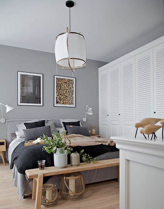 a chic modern bedroom done in greys, with stained furniture, a large shutter door closet right here and a catchy pendant lamp