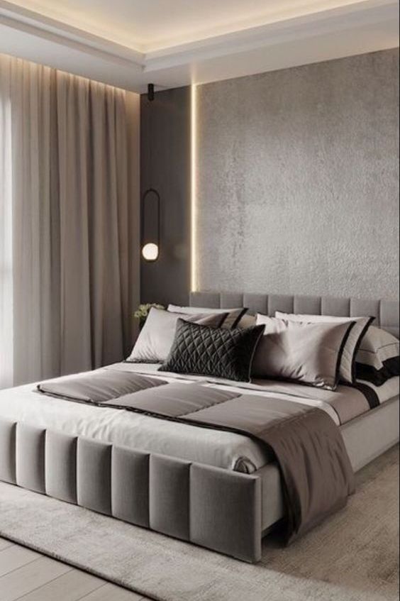 A clean contemporary bedroom with grey walls, built in lights on the ceiling, a large upholstered bed and neutral textiles is a lovely space
