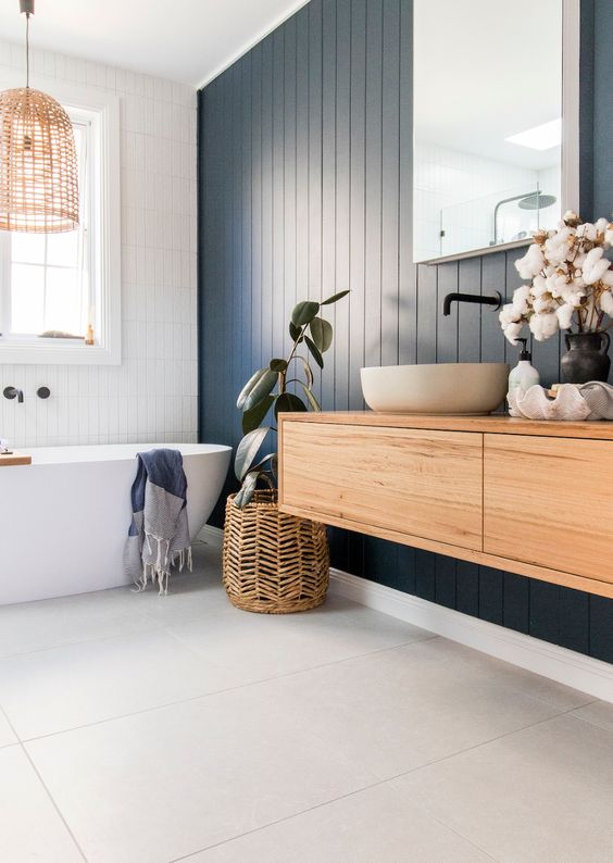 a contemporary bathroom with a navy planked accent wall, an oval tub, a floating vanity and a round tub, woven touches