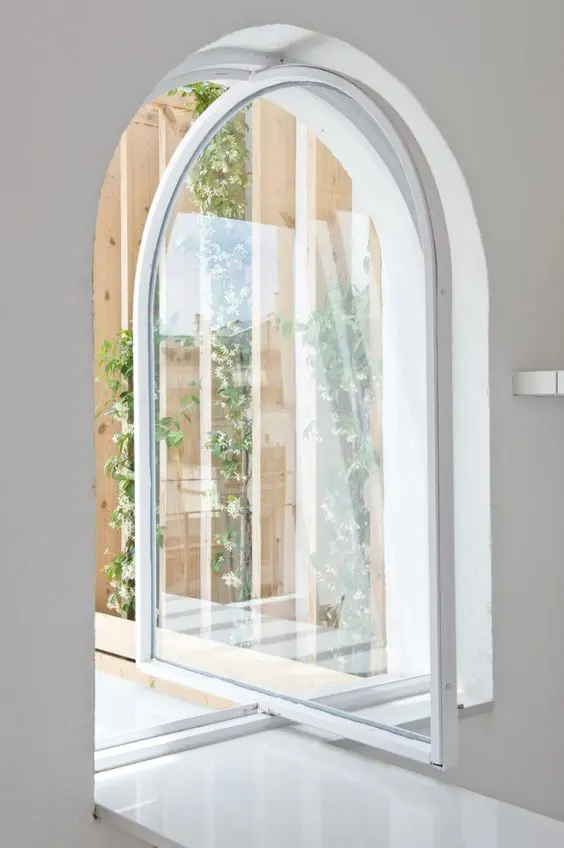 a cool white arched metal frame and glass pivot door that leads to the garden is a gorgeous idea to rock