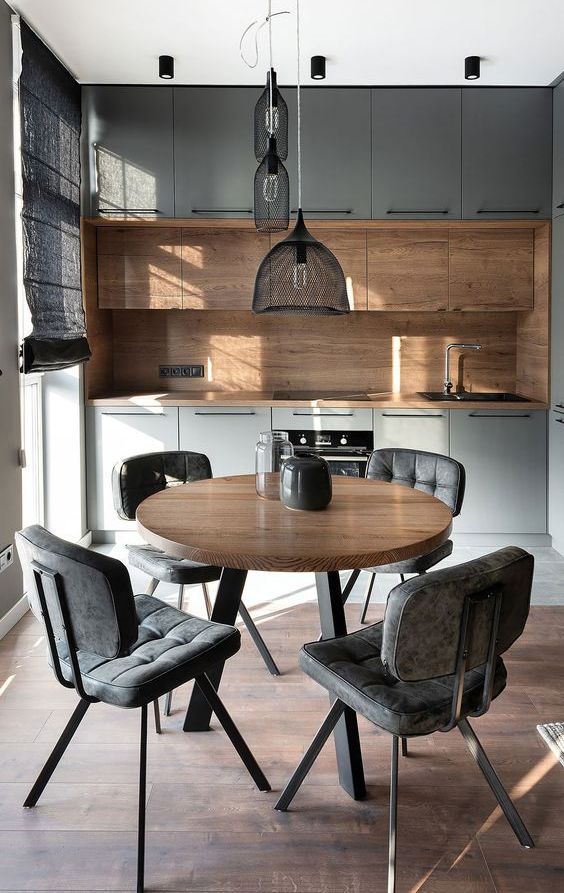 A gorgeous contemporary kitchen with grey and rich stained cabinets, a matching stained wood backsplash and countertops, a cluster of pendant lamps over the dining space