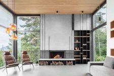a gorgeous contemporary living room with a view, a built-in fireplace and firewood storage, a grey sofa, leather chairs, pendant lamps