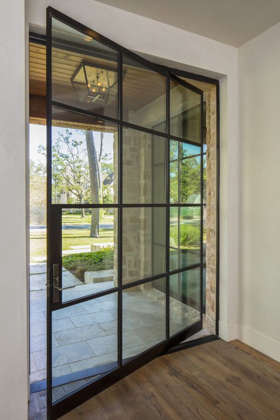 a large French pivot door like this one looks extremely elegant and chic and makes the entrace look very lightweight
