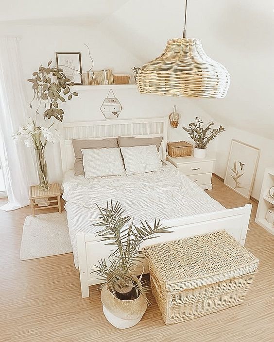 a neutral farmhouse bedroom with white and stained furniture, a woven pendant lamp and a woven chset, potted plants and a floating shelf