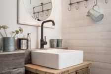 a rustic bathroom with white planked walls, reclaimed wood and a reclaimed wood vanity, dark metal fixtures and vintage touches