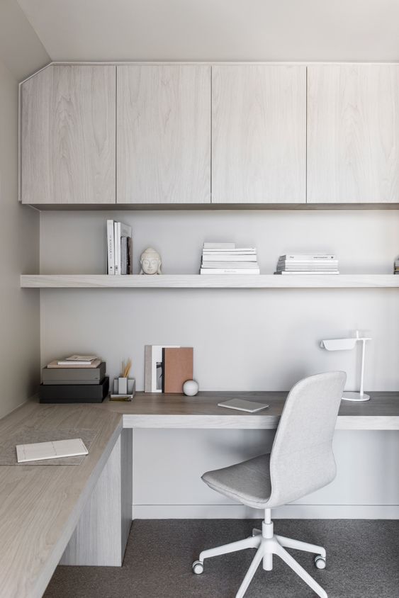 a sleek contemporary home office in light greys and white, with sleek storage units, an open shelf and a large corner desk plus a grey chair
