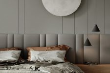 a striking contemporary bedroom in greys, with a grey accent wall, a wooden bed with an extended headboard and pendant lamp