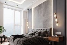a terrific contemporary bedroom with a lit up ceiling, a grey upholstered bed, black panels on the wall, pendant lamps and a cool view