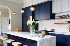 a two tone contemporary kitchen with navy and white cabinets, white stone countertops and a tile backsplash plus open shelves