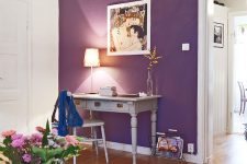 an elegant space with a purple accent wall, a vintage home office nook with grey furniture, bold blooms and white furniture
