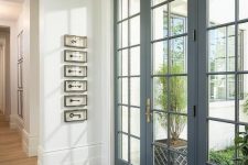 beautiful modern grey French doors and matching windows flood the entryway with light and make it look sophsiticated at the same time