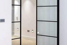 stylish black metal frame and glass pivoting doors are great for indoor use as they give a light feel to the interior and spearate the spaces