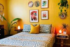 16 a bold bedroom with yellow walls, geometric bedding and a yellow pillow, mismatching nightstands, a colorful gallery wall and potted plants