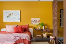 18 a chic bedroom with a mustard yellow accent wall, a white bed with colorful bedding, an upholstered bench and pretty artworks is cool