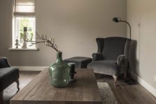 23 a light grey living room with taupe seating furniture, a low wooden coffee table, candles and a green vase with a branch