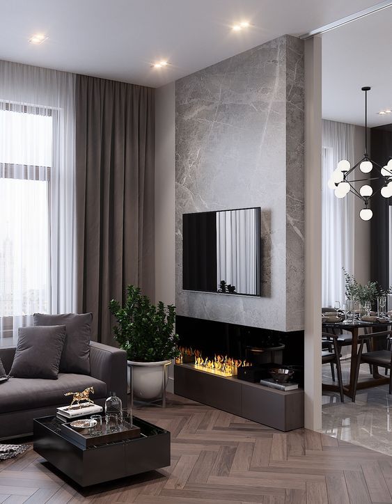 a refined modern living room with a taupe sofa, curtains and a fireplace unit, a black coffee table and a marble accent wlal