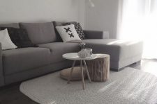 27 a small minimalist living room with a ledge gallery wall, a taupe sectional, a duo of coffee tables and printed pillows