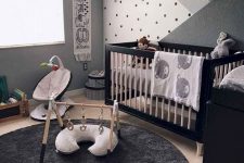 a black, grey and white nursery with a black and white crib, a black dresser, some baby furniture, shelves and toys is very cool