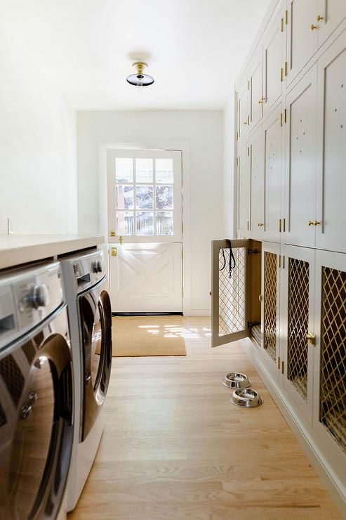 a neutral laundry room with shaker cabinets and lower cabinets turned into a multiple dog crate is a lovely solution