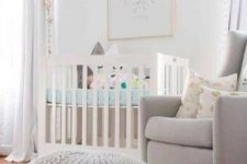 a neutral nursery with a star accent wall, a white crib with star pillows, a grey chair and a chunky knit pouf and star buntings is cool