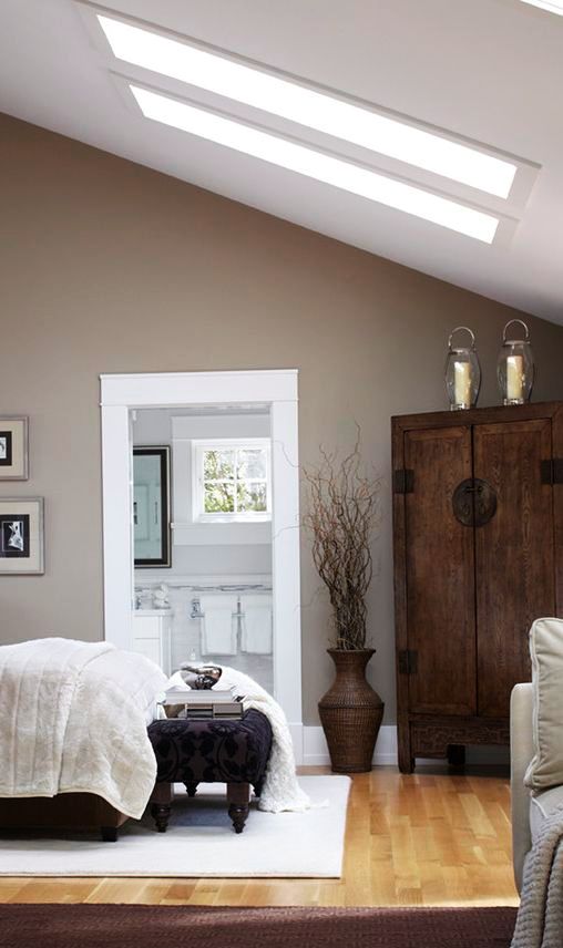 a cozy attic bedroom with taupe walls