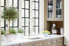 a sophisticated vintage kitchen with taupe shaker cabinetry, white stone countertops and a window backsplash is a gorgoeus idea