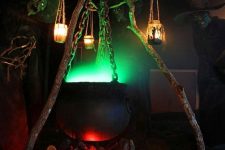 12 a fab Halloween outdoor decoration of a cauldron with green smoke, candle lanterns, jack-o-lanterns under it is a lovely idea