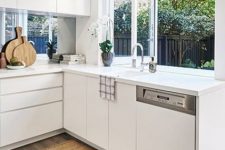 12 a minimalist white kitchen with sleek cabinets, a window backsplash and a folding window for fresh air or as a pass through window