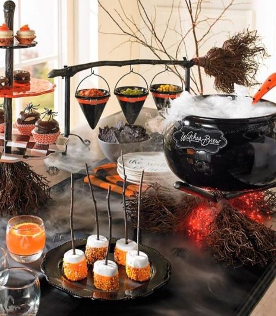 a Halloween party sweets table with a cauldron with lights, sweets, popcorn, marshmallows and macarons is amazing
