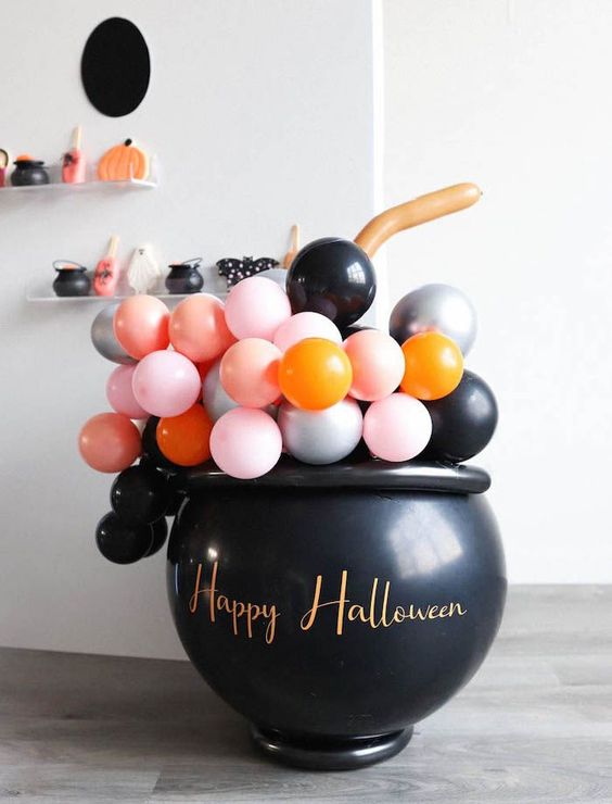 a witches' cauldron filled with colorful balloons is a fun and cool idea to rock at Halloween, will do for both adults' and kids' parties