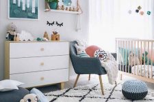 a Scandi nursery with bright touches – artworks, pillows, a pouf and a chair and some bright bedding in the crib is lovely