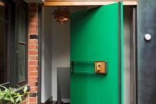a bold green oversized aquare pivot front door is a creative solution for a modern home, it will make a statement both with its color and design