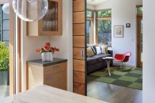 a light stained pocket door leading to a dining room is a cool addition to a mid-century modern interior and it adds a warm touch