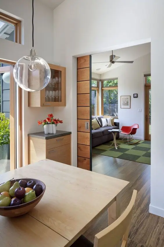 A light stained pocket door leading to a dining room is a cool addition to a mid century modern interior and it adds a warm touch