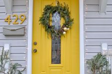 a lovely marigold front door with a glass pane, with a yellow house number on the wall styled for window is amazing
