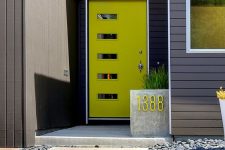 a mid-century modenr neon green front door with glass pants and a concrete planter with a neon green house number for a modern home