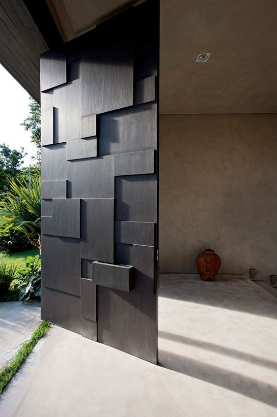 a modern sculptural and geometric oversized black front door is a cool idea for any modern or contemporary home