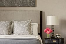 a refined greige bedroom with a greige bed, black elegant nightstands, an upholstered bench and an abstract artwork over the bed