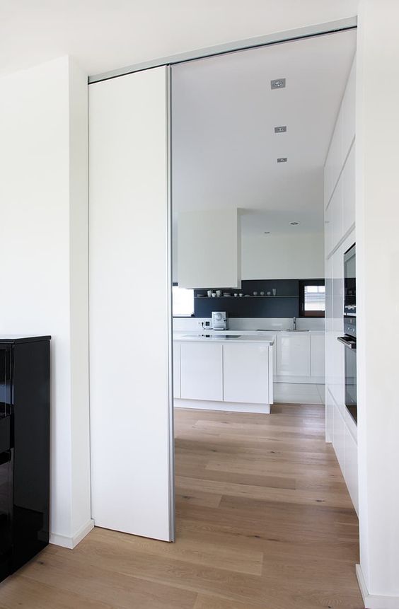 a sleek white pocket door is a cool and minimalist way to separate the spaces without spoiling any interior and look