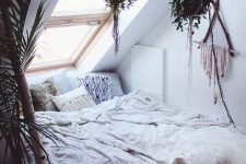 a small attic bedroom with a skylight as the only window looks very cozy and wlecoming